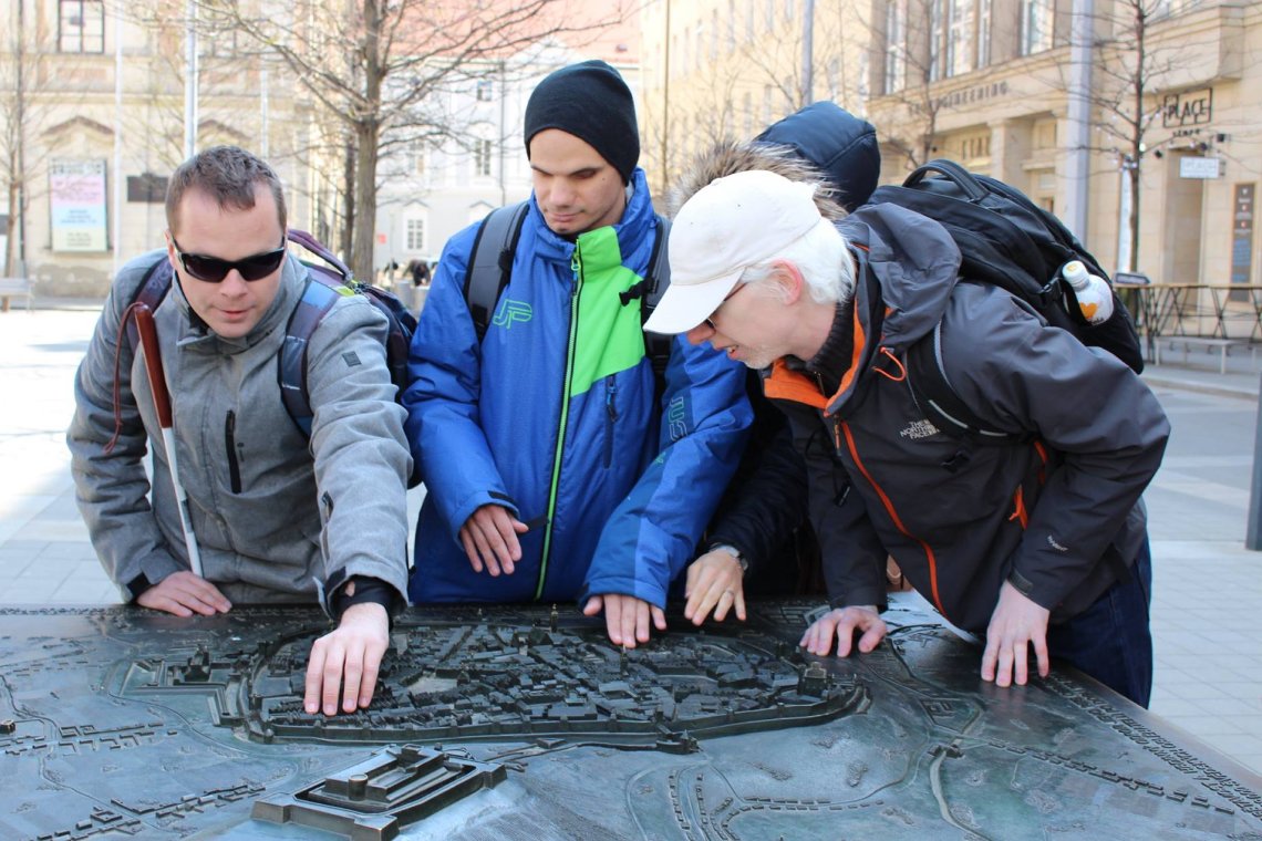 Four people using a tactile map