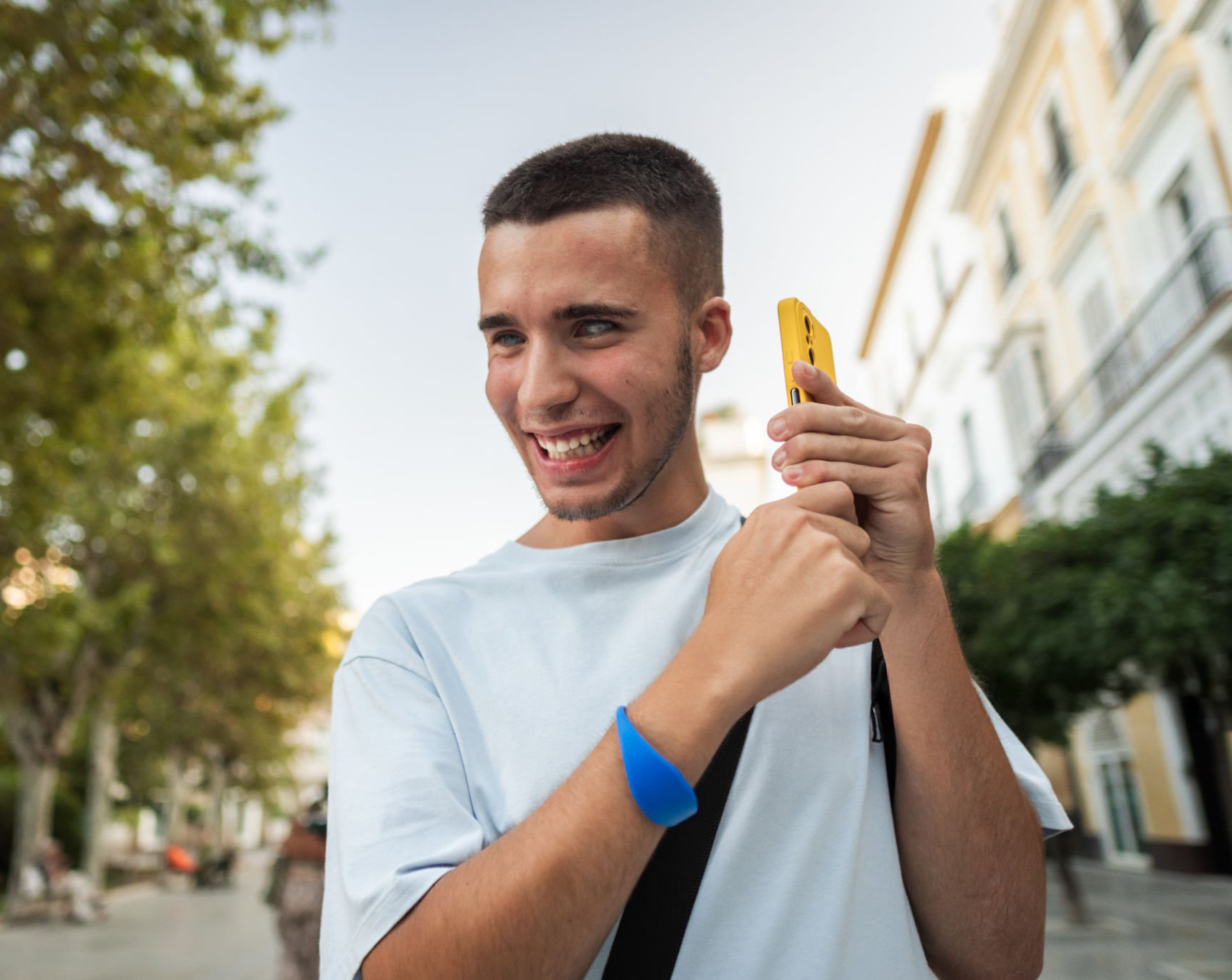 young blind man smiling while holding a smartphone to his ear
